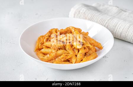 Portion of penne pasta with orange pesto sauce close up Stock Photo