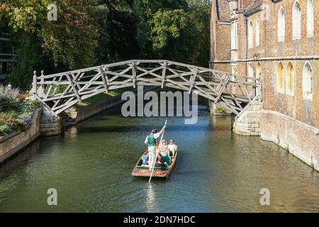 Tourists on punts on the River Cam under Mathematical Bridge in Cambridge Cambridgeshire England United Kingdom UK