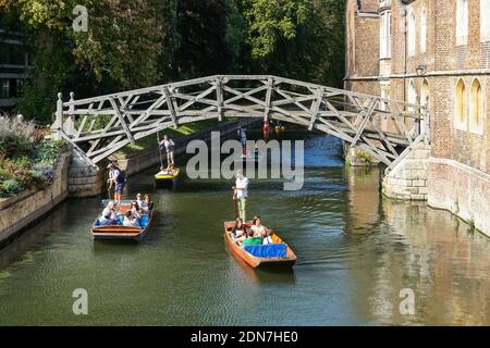 Tourists on punts on the River Cam under Mathematical Bridge in Cambridge Cambridgeshire England United Kingdom UK