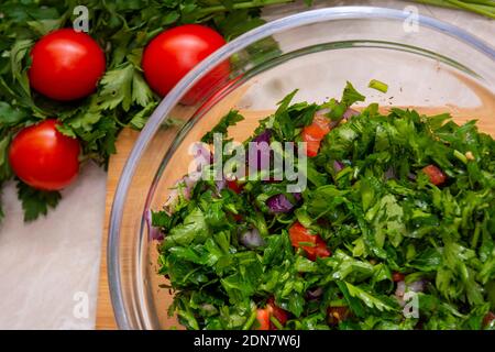 Close up on Tabbouleh salad made with parsley, cherry tomatoes, onion, lemon, olive oil and basil Stock Photo