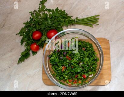 Close up on Tabbouleh salad made with parsley, cherry tomatoes, onion, lemon, olive oil and basil Stock Photo
