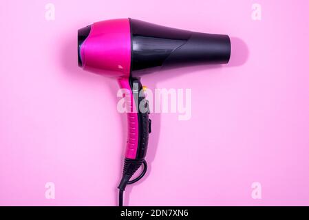 Black and Pink Hairdryer on light pink background - hairstyle tool Stock Photo