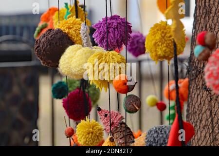 Balls of brightly coloured wool decorate the side of a bus shelter in Bradninch, Devon. Stock Photo