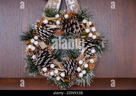 December 2020 - Milan: Christmas wreath hanging on a wooden door Stock Photo