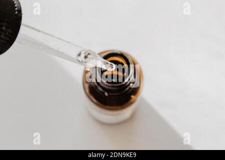Close-up Of Pipette Over Bottle Against White Background
