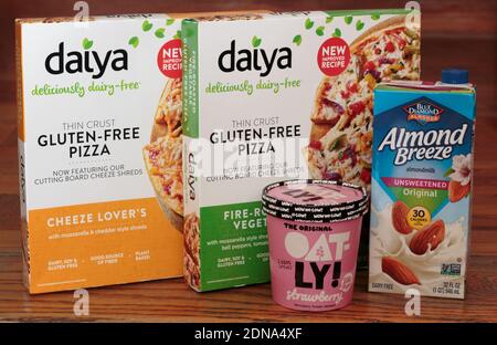 illustrative editorial of dairy free and gluten free products, daiya pizza, oatly oat milk ice cream, and blue diamond almond breeze almond milk Stock Photo