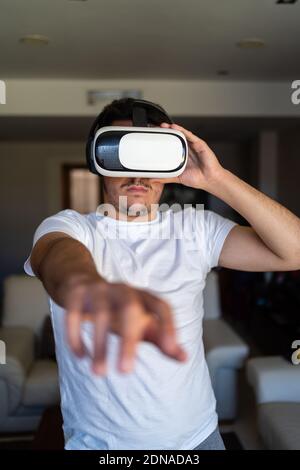 Young guy exited using virtual reality glasses Stock Photo