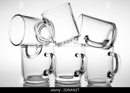 Thick glass mugs stacked. Drinking water storage containers. Light  background Stock Photo - Alamy