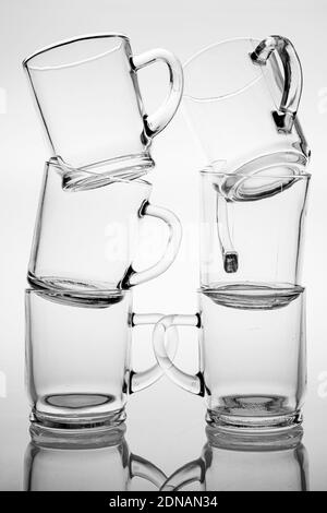 Thick glass mugs stacked. Drinking water storage containers. Light  background Stock Photo - Alamy