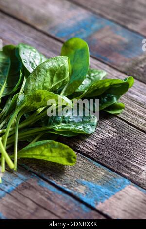spinach leaves on textured old wood planks, vertical closeup Stock Photo