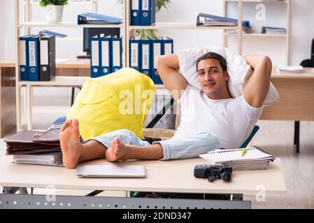 Young employee looking after newborn at workplace Stock Photo