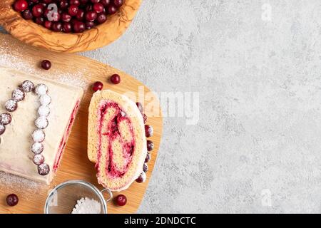 Homemade biscuit sweet roll with cranberries and cream on gray table, copy space, top view, flat lay Stock Photo