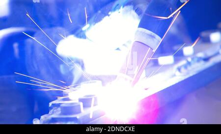 Gas tungsten arc welding GTAW torch, close up of weld electrode on metal sparks light background Stock Photo