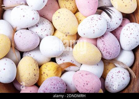 Easter holidays decoration. Easter sweets for children. Close-up. Top view. White yellow pink eggs for Easter treat. Stock Photo