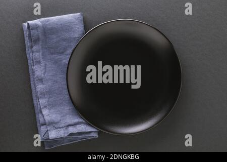 Empty black plate and napkin on a dark background. Food background. Stock Photo