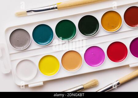 Set of watercolor paints and brushes for painting, top view. Stock Photo
