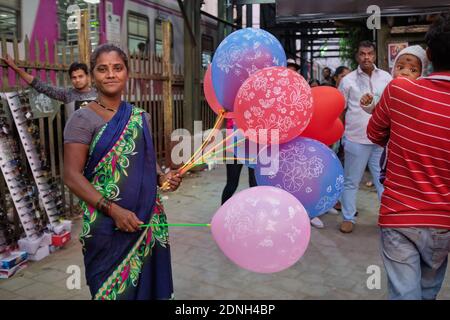 A friendly female balloon vendor outside Marine Lines railway station in Mumbai, India Stock Photo