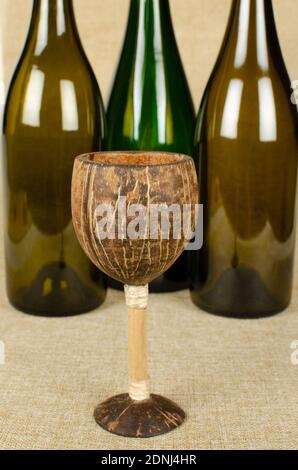 Coconut Shell  wine glass with three wine bottles not in Focus Stock Photo