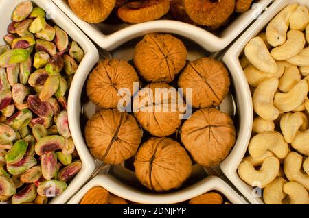 Dried Fruit Almonds, Green Pistachio, Walnut with Shell, dried Fig and Cashew nuts in white plate . Top angle. Studio Shot Stock Photo