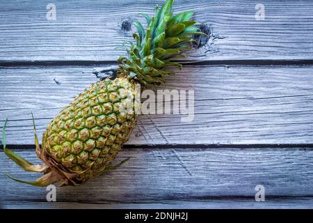 View of a pineapple against a wooden background. Use for fruit concept. Stock Photo