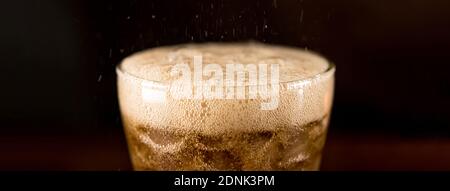 Close up panoramic banner image of cold sparking cola sodar soft drink in the glass with foam bubble Stock Photo