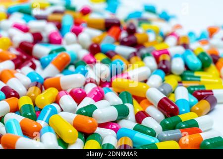 Selective focus on multi-colored antibiotic capsule pills. Antibiotic drug resistance concept. Pile of colorful capsule pills. Pharmaceutical industry Stock Photo