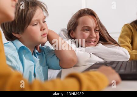 Cheerful teen schoolgirl smiling, studying with her classmates Stock Photo