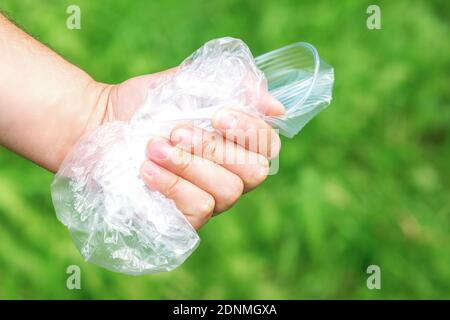 The person holds used crumpled plastic debris in his hand. Environmental problem concept. Stock Photo