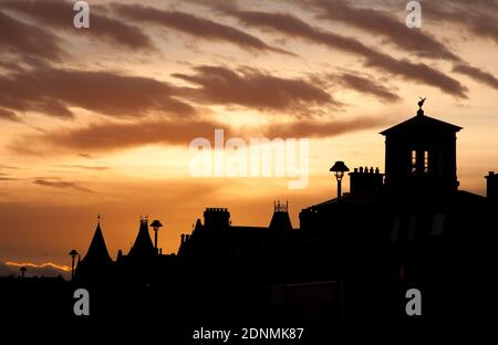 Portobello, Edinburgh, Scotland, UK. 18 December 2020. A short colourful sunrise this morning, temperature eight degrees at the seaside. Pictured: silhouette of houses on the promenade of the seasidetown. Credit: Arch White/Alamy Live News. Stock Photo