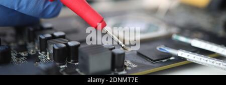 Gloved master holds probe over microcircuit closeup Stock Photo
