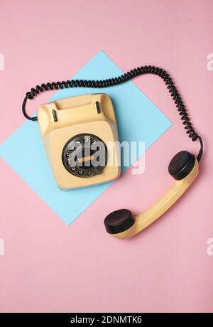 Retro rotary phone from 80s on a colored pastel background. Top view, minimalism Stock Photo