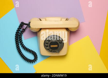 Retro rotary phone from 80s on a colored pastel background. Top view, minimalism Stock Photo