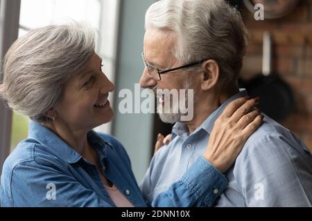Sincere middle aged woman looking into eyes of old husband. Stock Photo