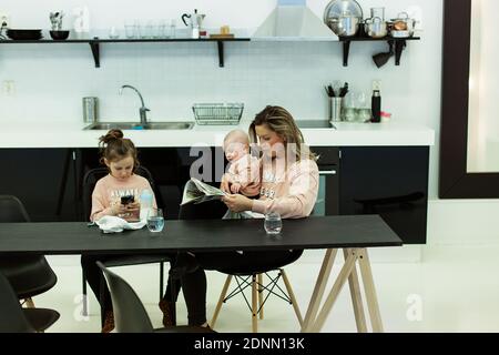 Mother with children in kitchen Stock Photo
