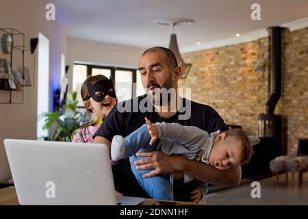 Man with children using laptop Stock Photo