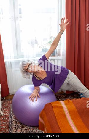 Senior woman exercising with fitness ball Stock Photo