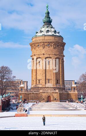 Mannheim, Germany. January 31th, 2010. A person is standing in front of the Wasserturm (Water Tower) at the Friedrichsplatz after a snowfall at the en Stock Photo