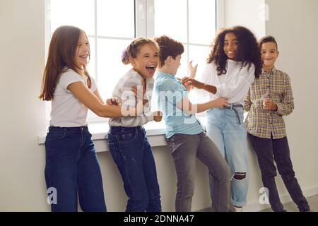 Group of children playing and laughing during recess at school or fun party at home Stock Photo