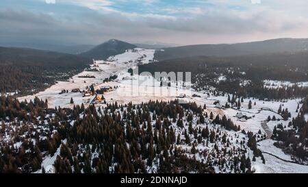 Winter aerial view of mountain landscape and large meadow at Jizerka settlement,Czech republic. Winter nature in cloudy day.Peat bogs of Jizerka.Snowy Stock Photo