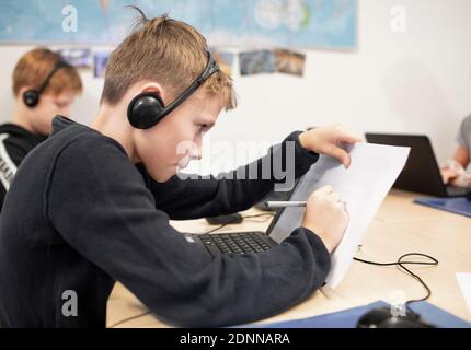Girl in classroom using laptop Stock Photo