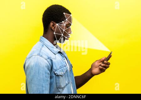 Mobile biometric identification and verification or detection concept. face ID scaning or unlocking technology. serious man using facial recognition o Stock Photo