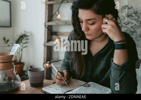 Woman making notes in diary Stock Photo