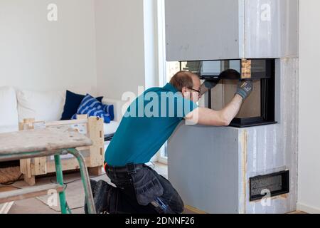 Man installing fireplace Stock Photo
