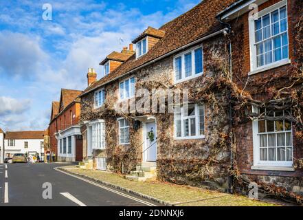 Georgian style terraced cottage (Church Hill House) in Church Hill, Midhurst, West Sussex, in winter with a Christmas wreath on its blue front door Stock Photo