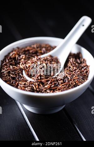 Uncooked red rice. Raw wild rice in bowl. Stock Photo