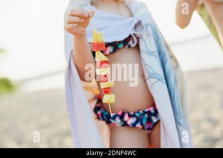 Girl holding fruit kebab Stock Photo