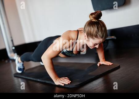 Woman doing push-ups in gym Stock Photo