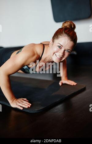 Woman doing push-ups in gym Stock Photo