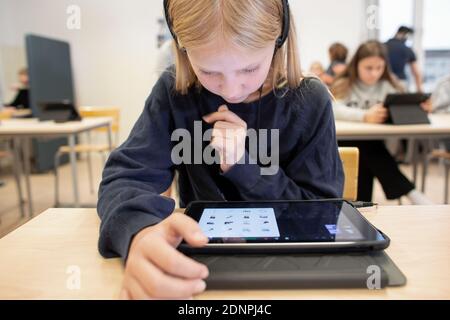 Girl in classroom using digital tablet Stock Photo