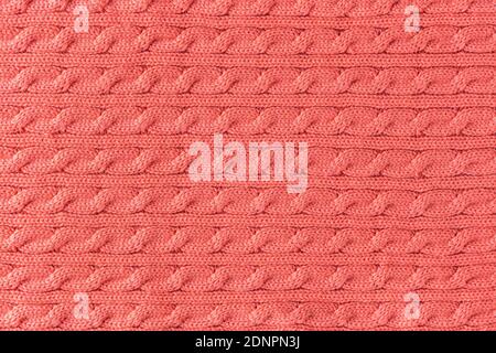 Cropped close up shot of pink woolen knitting pattern of fall / winter season warm sweater, clearly visible fiber texture of stylish hipster knitwear Stock Photo